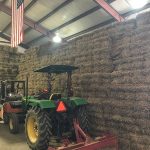 Hay stacked in storage area with tractor